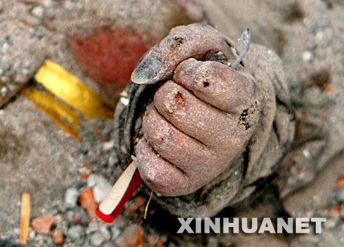 这是5月16日晚拍摄的四川省绵竹市汉旺镇东汽中学发掘现场的一幕――一名死难学生手里紧紧攥着一支笔。 