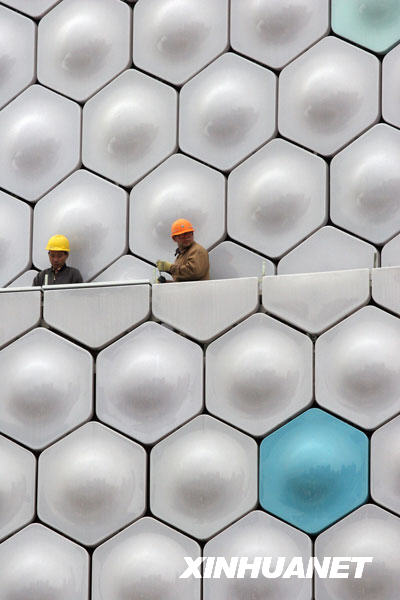 11月29日，两位工人在上海世博园区信息通信馆施工现场忙碌。随着2010年上海世博会临近，上海世博园区大部分场馆已初现雄姿。